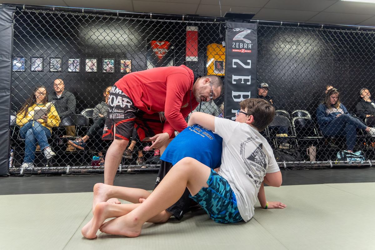 Students drilling grappling while families watch